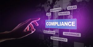 Hand reaching towards word cloud with compliance in the center